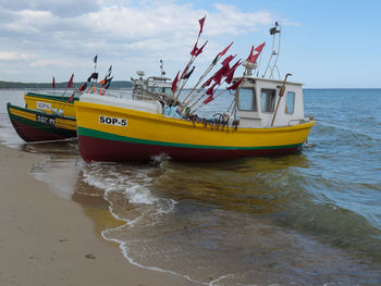 Nautical vessel on beach against sky