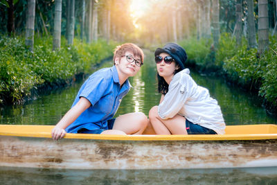 Young friends enjoying in boat on lake at park