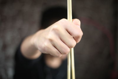 Close-up of man holding chopsticks