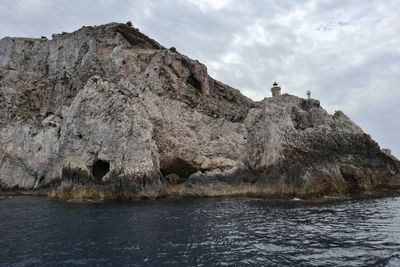 Rock formations by sea against sky