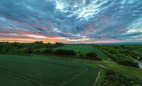 Scenic view of agricultural field against sky during sunset