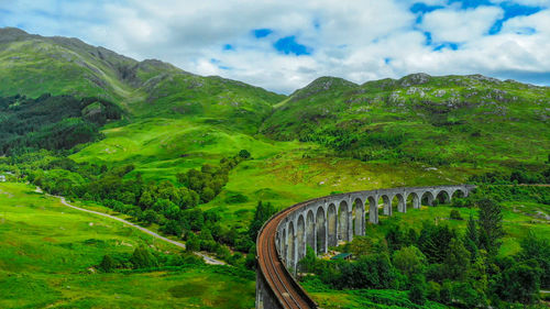 Scenic view of bridge over mountains against sky