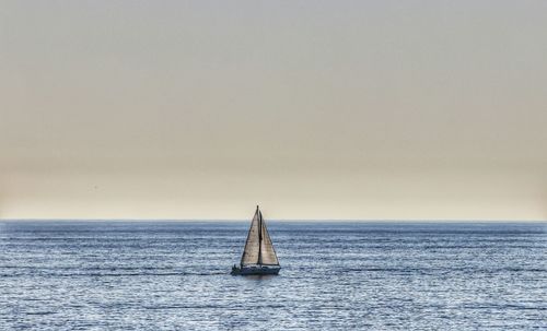 Sailboat sailing on sea against sky