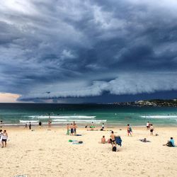 Panoramic view of people on beach against sky