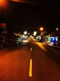 Road passing through illuminated city at night