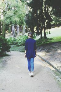 Rear view of young woman walking on road