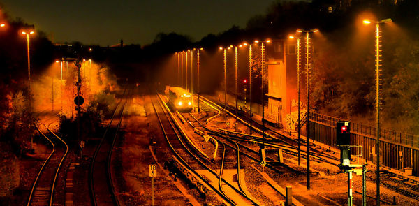 Illuminated railroad tracks at night