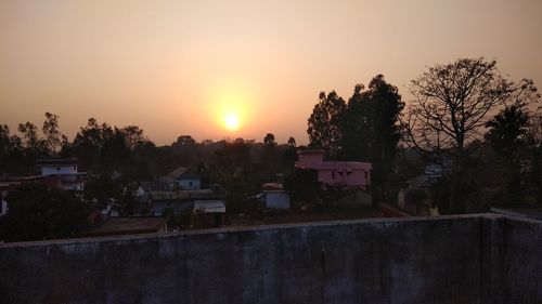 Scenic view of city against sky at sunset