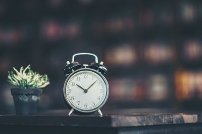 Close-up of clock on potted plant on table