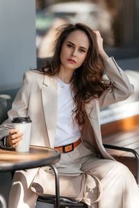 Young woman in white pantsuit and white t-shirt in city location