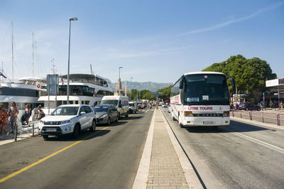 Cars on road against sky in city
