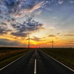 Road by land against sky during sunset