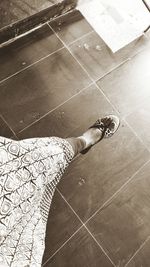 Low section of woman standing by swimming pool