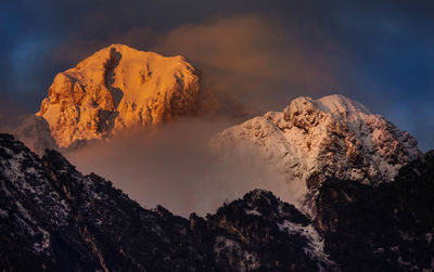 Low angle view of snowcapped mountains against sky