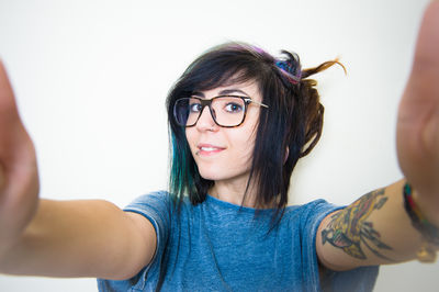 Close-up portrait of young woman against white background