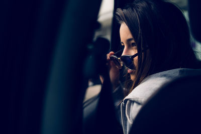 Teenage girl in sunglasses looking through car window