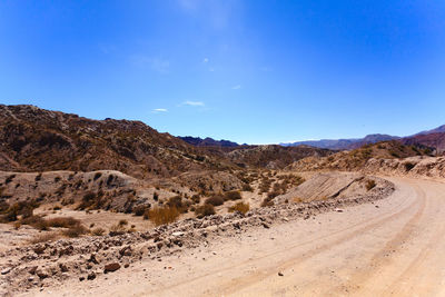 Scenic view of desert against blue sky