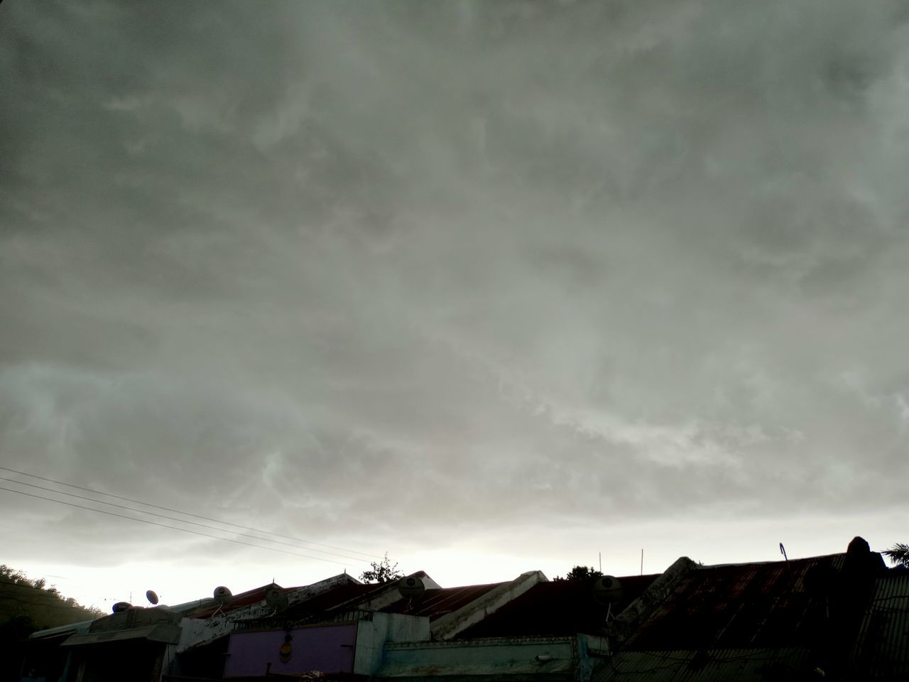 LOW ANGLE VIEW OF HOUSES AGAINST SKY AT SUNSET