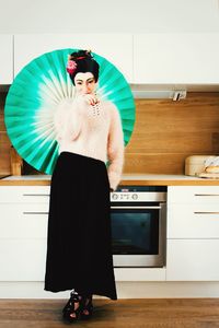  woman dressed as geisha standing in kitchen