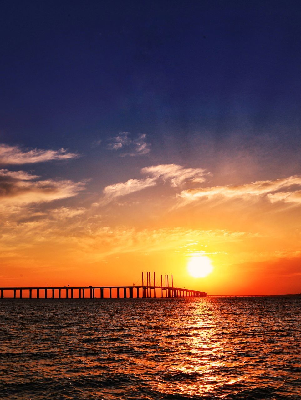 sunset, sky, orange color, sea, water, silhouette, scenics, sun, tranquility, beauty in nature, tranquil scene, nature, outdoors, sunlight, built structure, horizon over water, cloud - sky, waterfront, architecture, no people, travel destinations, day