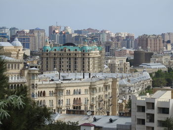 Buildings in city against clear sky