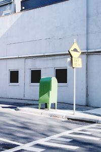 Road sign on street against building