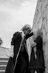 Rear view of woman standing against wall