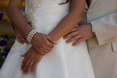 Midsection of couple holding hands