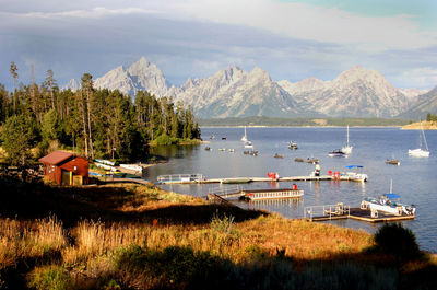 Lake by mountains against cloudy sky