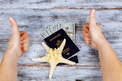 Cropped hands of woman gesturing by objects on table