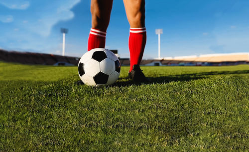 Low section of man playing soccer at stadium