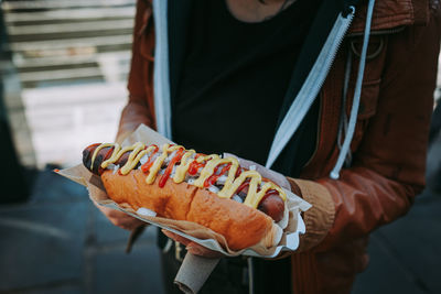 Close-up of hand holding hot dog