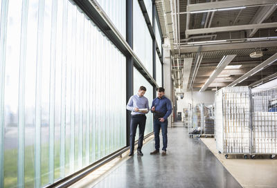 Two men in factory shop floor examining product