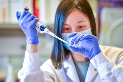 Portrait of dentist holding dentures in laboratory