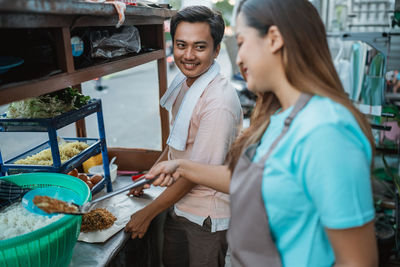 Portrait of smiling friends holding food