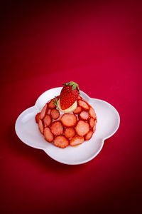 High angle view of strawberries on table against red background