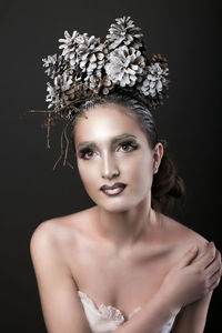 Close-up portrait of beautiful young woman against gray background