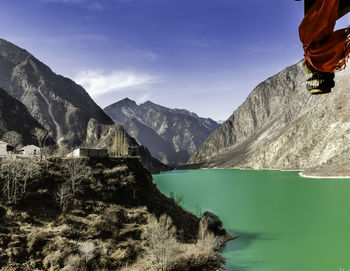 Scenic view of lake by mountains against sky