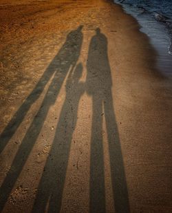 Shadow of parents with child on beach