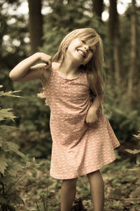 Portrait of cute cheerful girl in forest