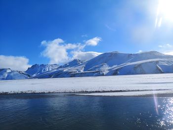 Scenic view of snowcapped mountains against blue sky