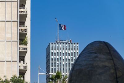 Low angle view of flag against buildings in city