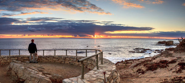 Man standing against sea during sunset