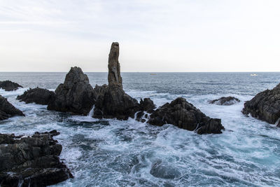 Scenic view of rocks in sea against sky