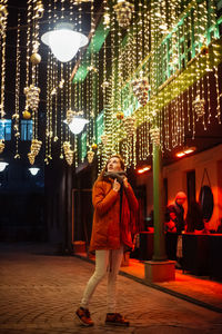 Rear view of people walking at illuminated restaurant