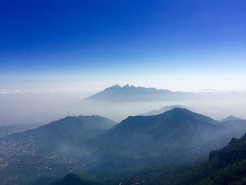 Scenic view of mountains against blue sky