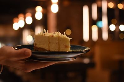 Cropped image of hand holding cake