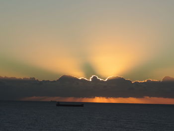 Scenic view of sea against dramatic sky during sunset