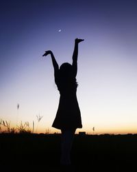 Silhouette woman standing on field against clear sky