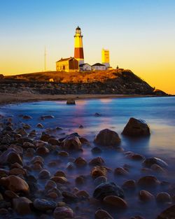 View of lighthouse at beach during sunset